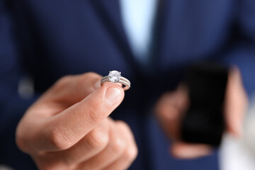 Making proposal. Man with engagement ring indoors, closeup