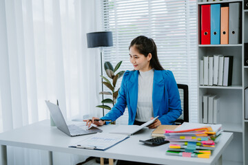 Asian female accountant businesswoman analyze using laptop to collect financial data in office....
