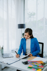 Asian female accountant businesswoman analyze using laptop to collect financial data in office....
