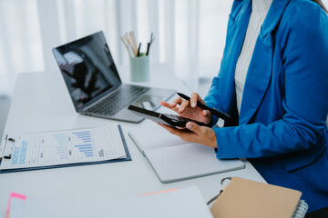 Asian female accountant businesswoman analyze using laptop to collect financial data in office....