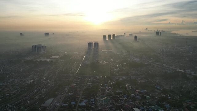 Larkin city with a foggy sky and a sun in the background. The sun is setting and the sky is hazy