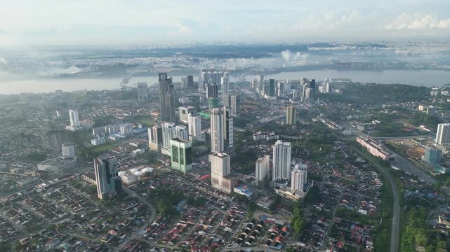 A city with a river in the background. The city is full of tall buildings. The sky is cloudy. Aerial view Larkin, Johor