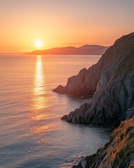 Serene Sunset Over Rocky Coastline with Calm Waters and Mountains