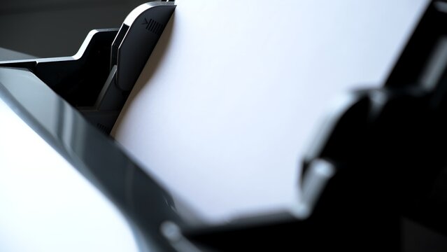 Printer paper tray close-up. Loading a sheet. Printing process. A paper comes into the color inkjet printer. Office equipment. Side view. Working B-roll. Copy space. High quality.