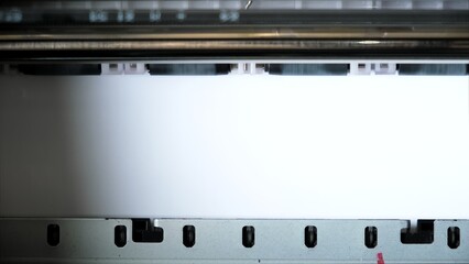 The clean paper sheet rolls in printer without paints. Printing process of color inkjet printer. The rolles is rolling inside of device. The printer has run out of ink. High quality.