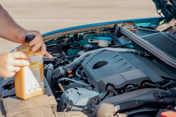 Pouring engine oil into a car engine