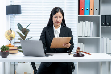 Woman Legal Professional at Desk: An Asian woman, engrossed in her work as a legal professional,...