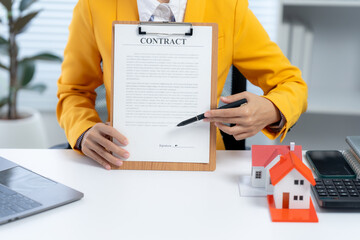 Contract Negotiation: A person, poised in professional attire, points at a contract with a pen,...