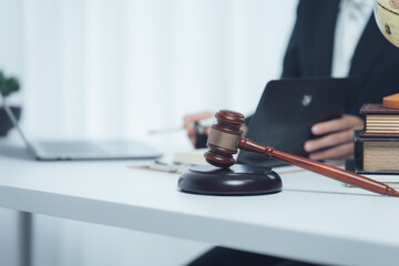 Judicial Proceedings: An evocative image of a wooden gavel resting on a sound block alongside legal documents and other instruments in a courtroom or law office.