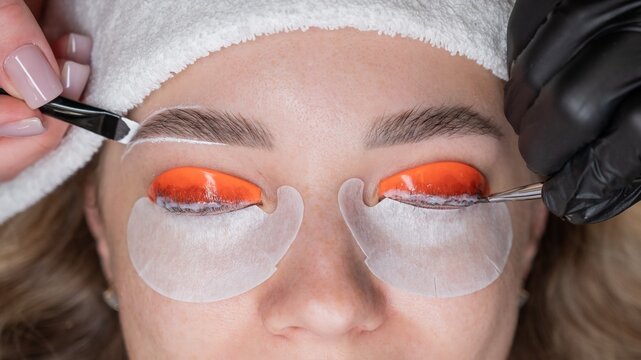 The process of professional lamination and dyeing of eyelashes and eyebrows in the salon. Four-handed procedure. - Powered by Adobe