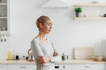 Quarrel, problems at relationships, breakup, negative emotions and divorce. Lonely upset adult woman sad at modern kitchen interior at home after husband left, copy space