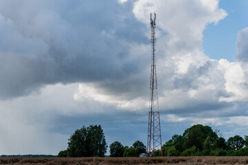 Obraz premium Cellular communication tower in rural landscape under dramatic cloudy sky providing mobile signal and 5g data coverage for remote area telecommunication and wireless infrastructure