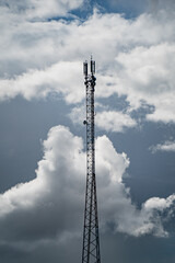 Cellular communication tower against dramatic cloudy sky in rural area symbolizing wireless signal transmission, mobile data coverage, and modern telecommunication infrastructure