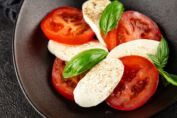 Caprese salad mozzarella and tomato, basil fresh delicious gourmet food background on the table rustic food top view copy space keto and paleo diet vegan and vegan food