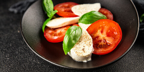 Caprese salad mozzarella and tomato, basil fresh delicious gourmet food background on the table rustic food top view copy space keto and paleo diet vegan and vegan food