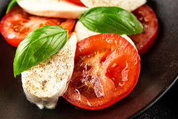 Caprese salad mozzarella and tomato, basil fresh delicious gourmet food background on the table rustic food top view copy space keto and paleo diet vegan and vegan food