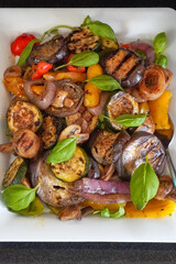 Healthy cooked eggplant dish with mixed vegetables served in white dish.