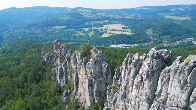 Discover the stunning dry rocks of Bohemian Paradise in Czechia, showcasing impressive sandstone formations surrounded by lush green forests and an expansive landscape. Ideal for climbing enthusiasts. - Powered by Adobe