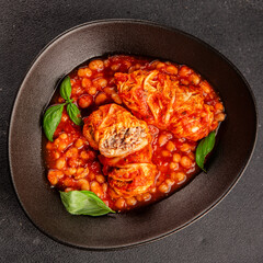 Stuffed cabbage tomato sauce with beans meat, cabbage, fresh delicious gourmet food background on the table rustic food top view copy space