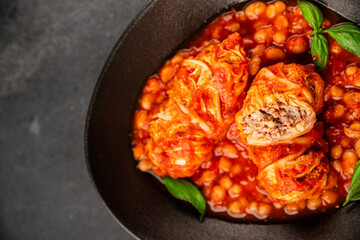 Stuffed cabbage tomato sauce with beans meat, cabbage, fresh delicious gourmet food background on the table rustic food top view copy space