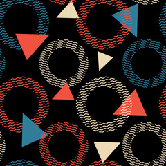 Colorful geometric pattern with red, blue, and beige triangles and circles on a black background, accented by wavy lines. A bold, modern design with strong contrast and visual rhythm.