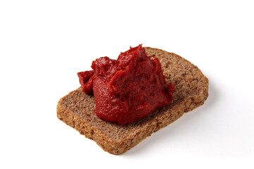 pile of tomato paste on a piece of rye bread isolated on white background.