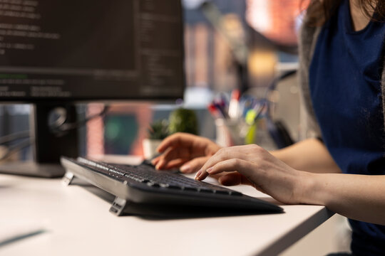 System administrator at office coding on her computer creating a software and works on implementing algorithms. IT expert building applications with a programming interface. Close up.