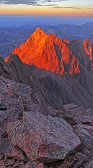 Obraz premium Sunrise illuminates a mountain peak.