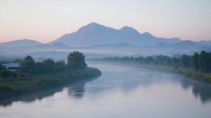 Misty riverbanks reflect a serene mountain range at dawn.