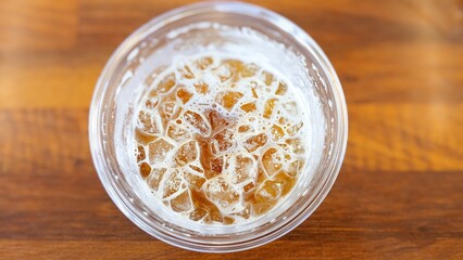 Top View of Iced Coffee in a Plastic Cup on a Wooden Table