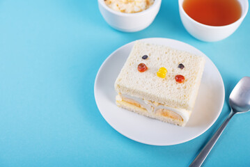 Japanese Egg Salad sandwich, Tamago Sando in the form of funny face on a blue background