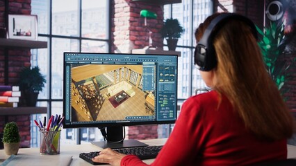 Professional architectural designer configures a floor plan on dual monitors, utilizing computer aided design tools. Woman uses digital rendering and interior decoration remodeling. Camera B.