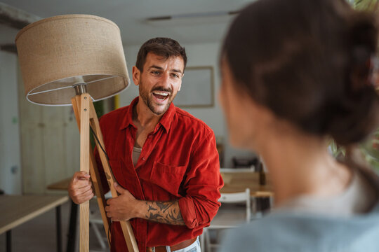 Interior designer showing floor lamp to client during home renovation