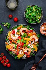 seafood salad with shrimp, mussels, squid, oranges, tomatoes, green lettuce and olemon dressing, top view