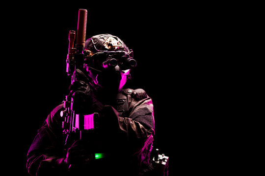 Tactical Operative in Combat Gear Highlighted by Dramatic Neon Lighting