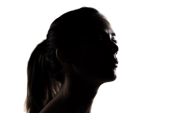 Silhouette portrait of a young woman, dramatic lighting in a studio setting