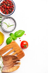 Food and cooking background, spices herbs, kitchen utensils, top view. Rose and black pepper, fresh rosemary, basil, tomatoes, olive oil and sea salt on white table