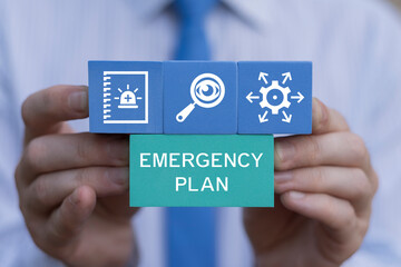 Business person holding blocks with icons sees the inscription: EMERGENCY PLAN. Concept of Emergency Response Preparedness Plan. Learn and prepare in emergency situation. Emergency Training.