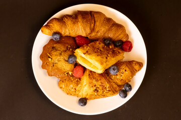 Flaky Croissant with Fresh Berries and Banana on Vibrant Yellow