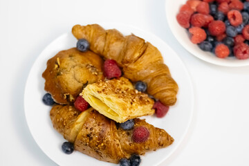 Flaky Croissant with Fresh Berries and Banana on Vibrant Yellow