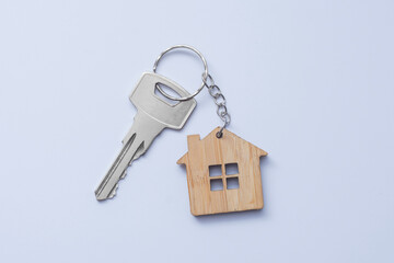 Key to the house with a wooden beet in the shape of a house. Real estate concept, mortgage and new house.