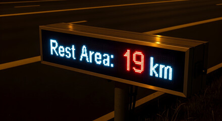 Obraz premium Rest Stop Digital Sign Illuminating Distance to Next Service Area on Highway