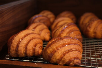 A close-up view of golden, flaky croissants topped with chocolate and nut sprinkles, arranged on a decorative plate. Ideal for themes of breakfast, food styling, and indulgent treats. High quality