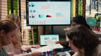 Goals oriented businesswomen dive deep into financial reports, leveraging graphs and indicators of corporate data to guide next strategic move with confidence. Company management. Camera A. - Powered by Adobe