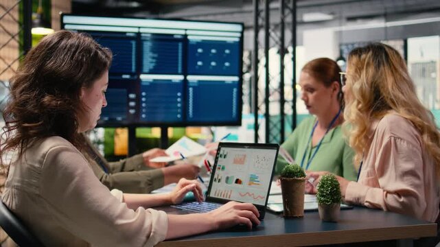 focused businesswoman analyzing graphs and data on laptop at the table, working with determination and strategic thinking. Aligning corporate objectives with performance indicators. Camera A.