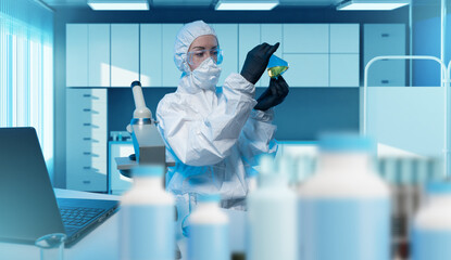 Scientist in protective suit analyzing chemical liquid in laboratory, working with high safety...