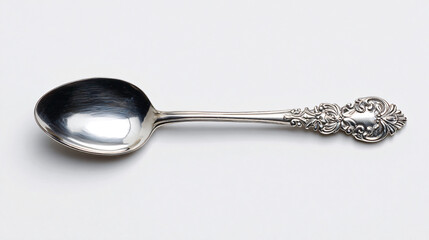 Ornate silver spoon with embossed Victorian floral patterns on a light background