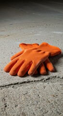 Orange work gloves on concrete