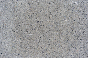 Coarse gray concrete surface with visible aggregate and rough texture, isolated and evenly lit. Suitable for backgrounds, design projects, or construction-related visual content.