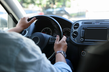 Man driving car with steering wheel, closeup